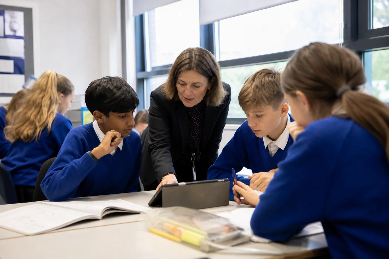 Teacher and learners use an AI-supported tool under clear teacher guidance in a UK classroom.