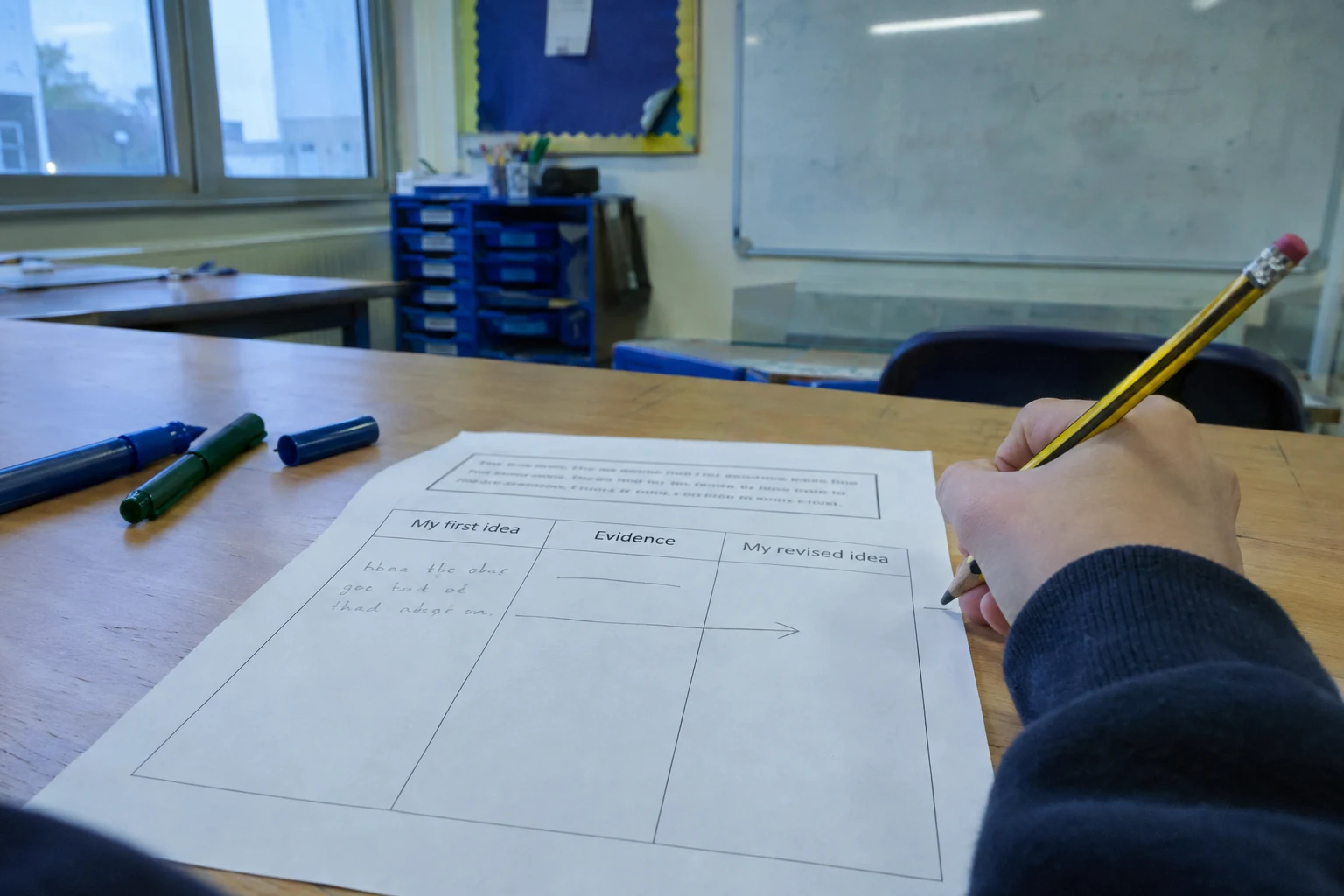 Illustrative close-up of a learner's worksheet with three columns: My first idea, Evidence, My revised idea, and an arrow from the first idea to the revised one