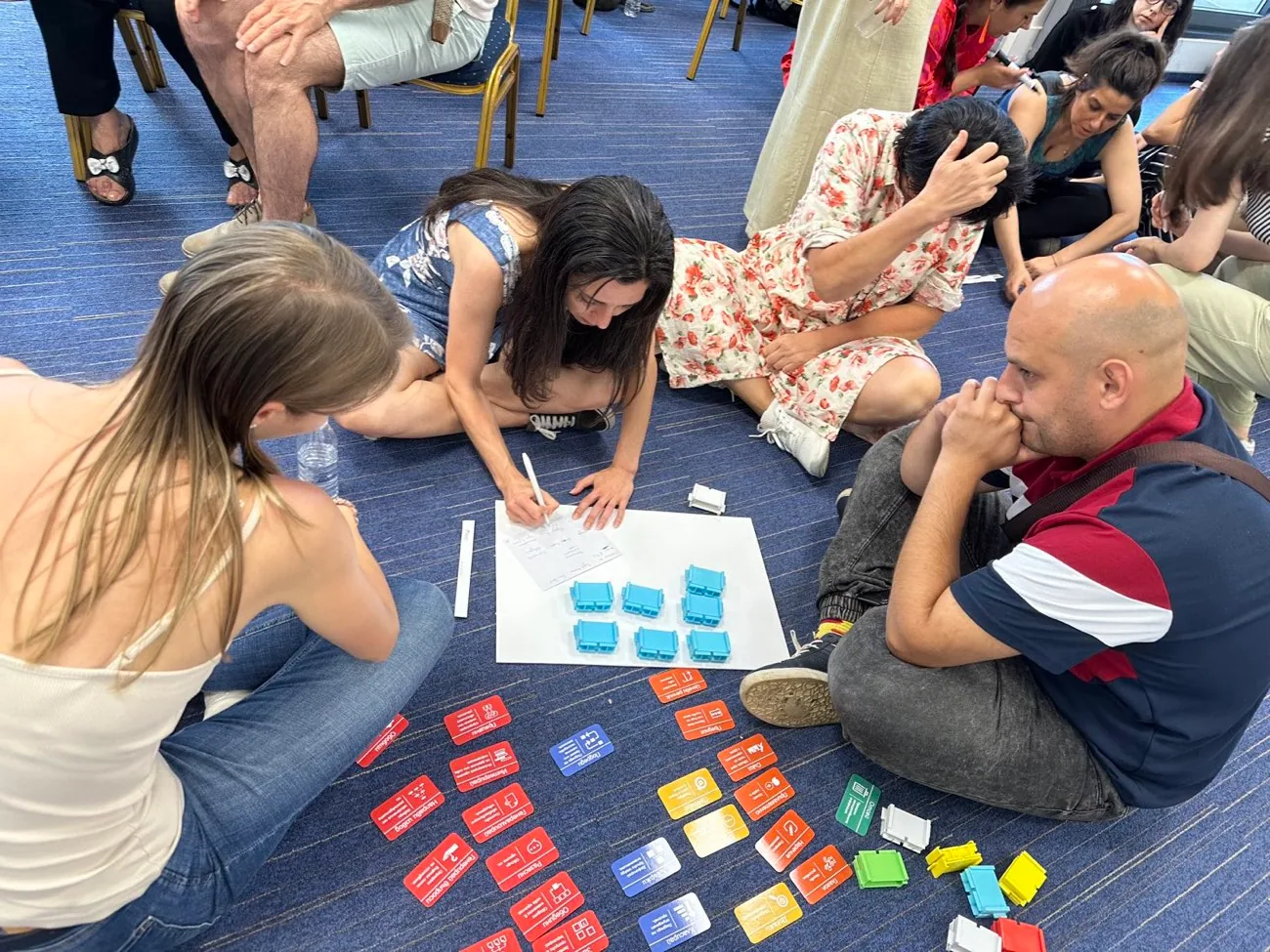 Teachers sitting on the floor sorting Thinking Framework command cards and Writer's Block.