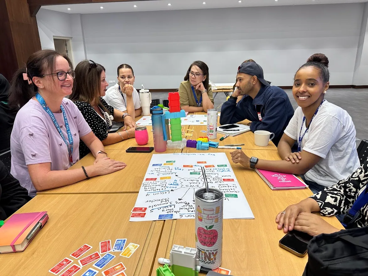 Six teachers at a table in a school hall with the unit they have just mapped on the Thinking Framework cards.