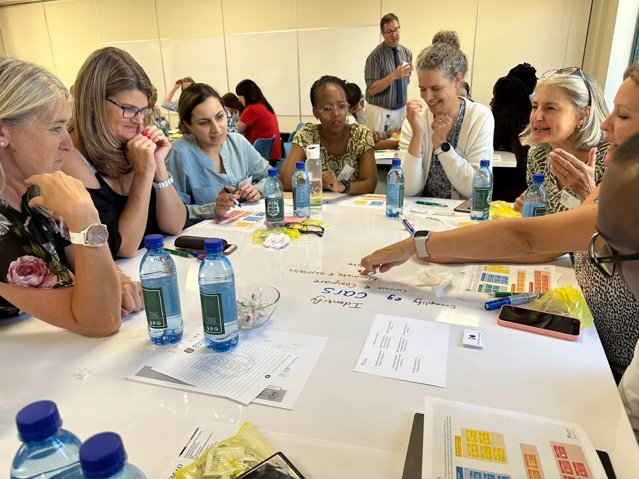 Teachers from several South African schools round a table, working on a graphic organiser together.