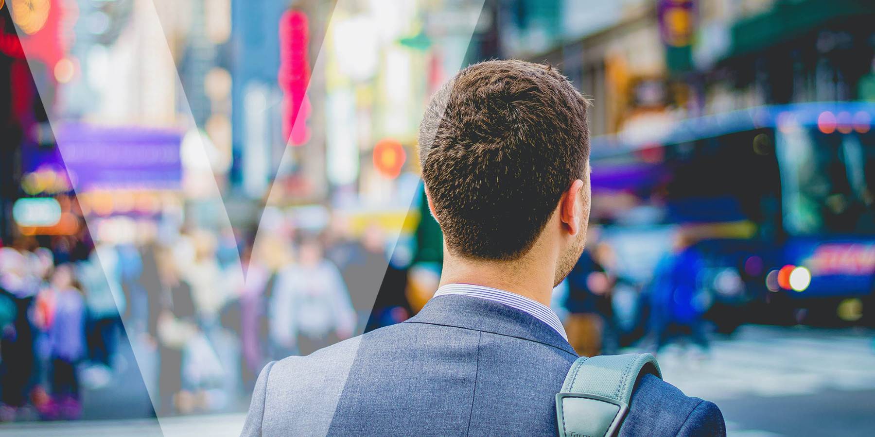 A man in suit walking through a crowded downtown