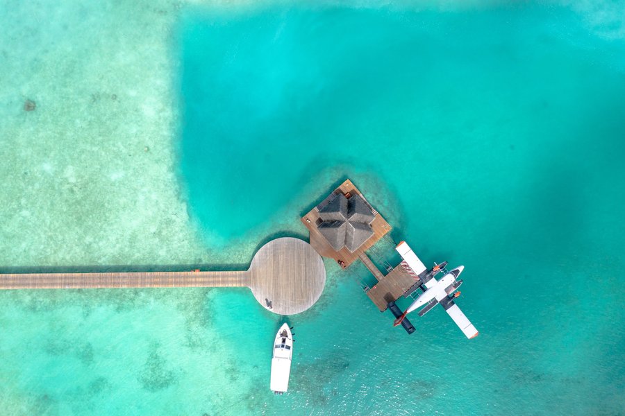 Idrovolante ormeggiato al pontile di una water villa alle Maldive, visto dall’alto