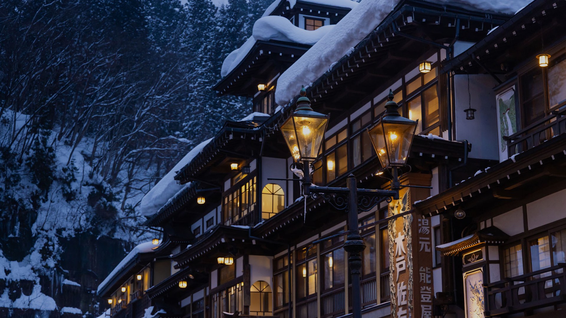 Il Notoya Ryokan di Ginzan Onsen sotto la neve, con i lampioni a gas accesi all’imbrunire