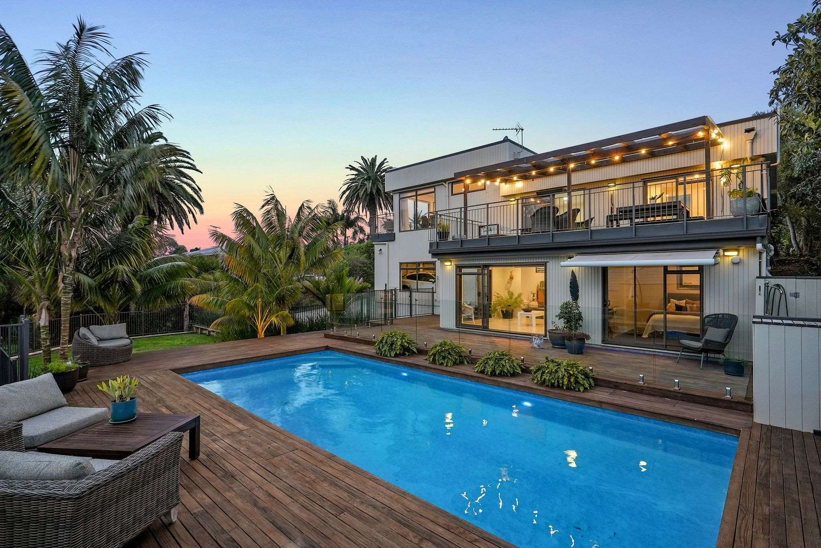Beach Road, Campbells Bay - family home at dusk with poolside deck