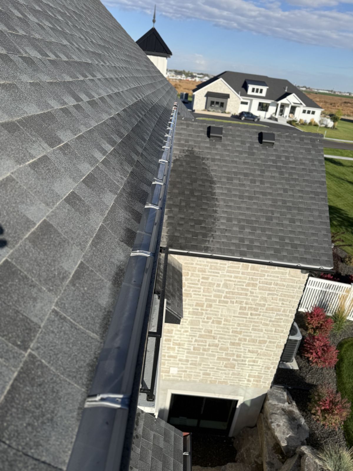Freshly cleared gutter along a shingle roof