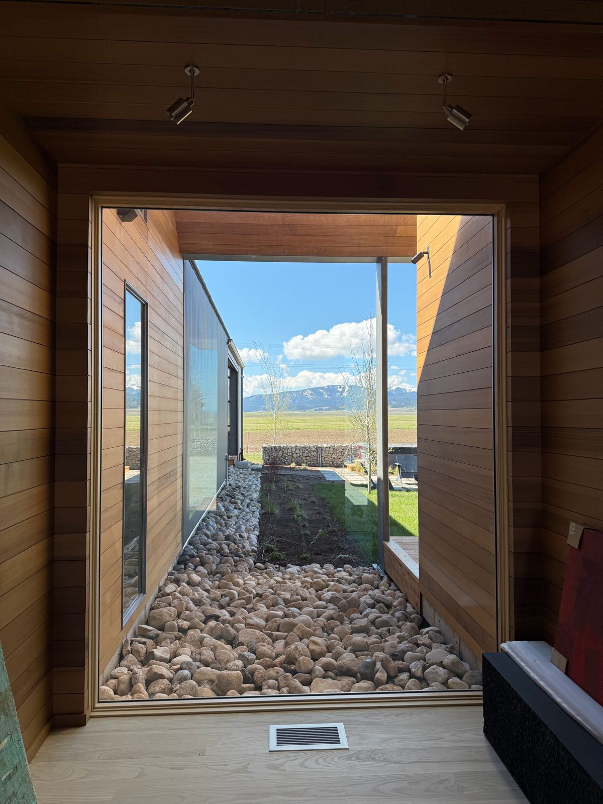 View through floor-to-ceiling courtyard glass toward the mountains in Driggs