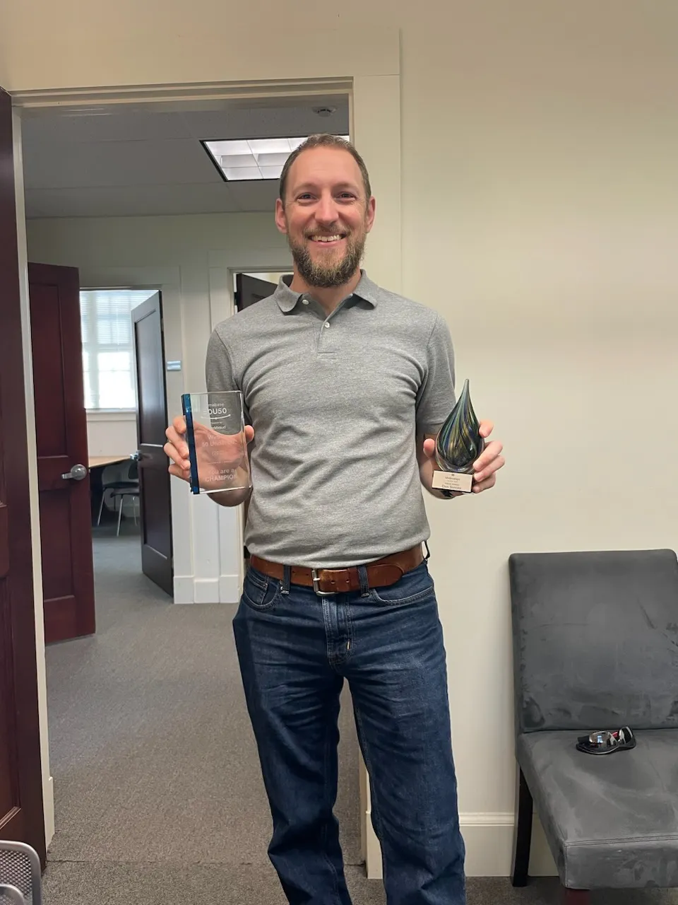 Dan posing proudly with his trophies of recognition from Almabase and Blackbaud