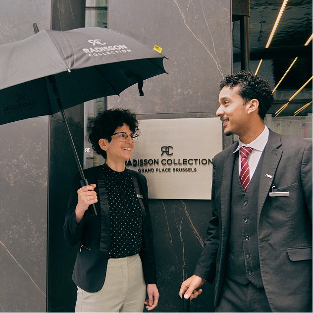 Hotel staff with a Dripdrop umbrella at the entrance