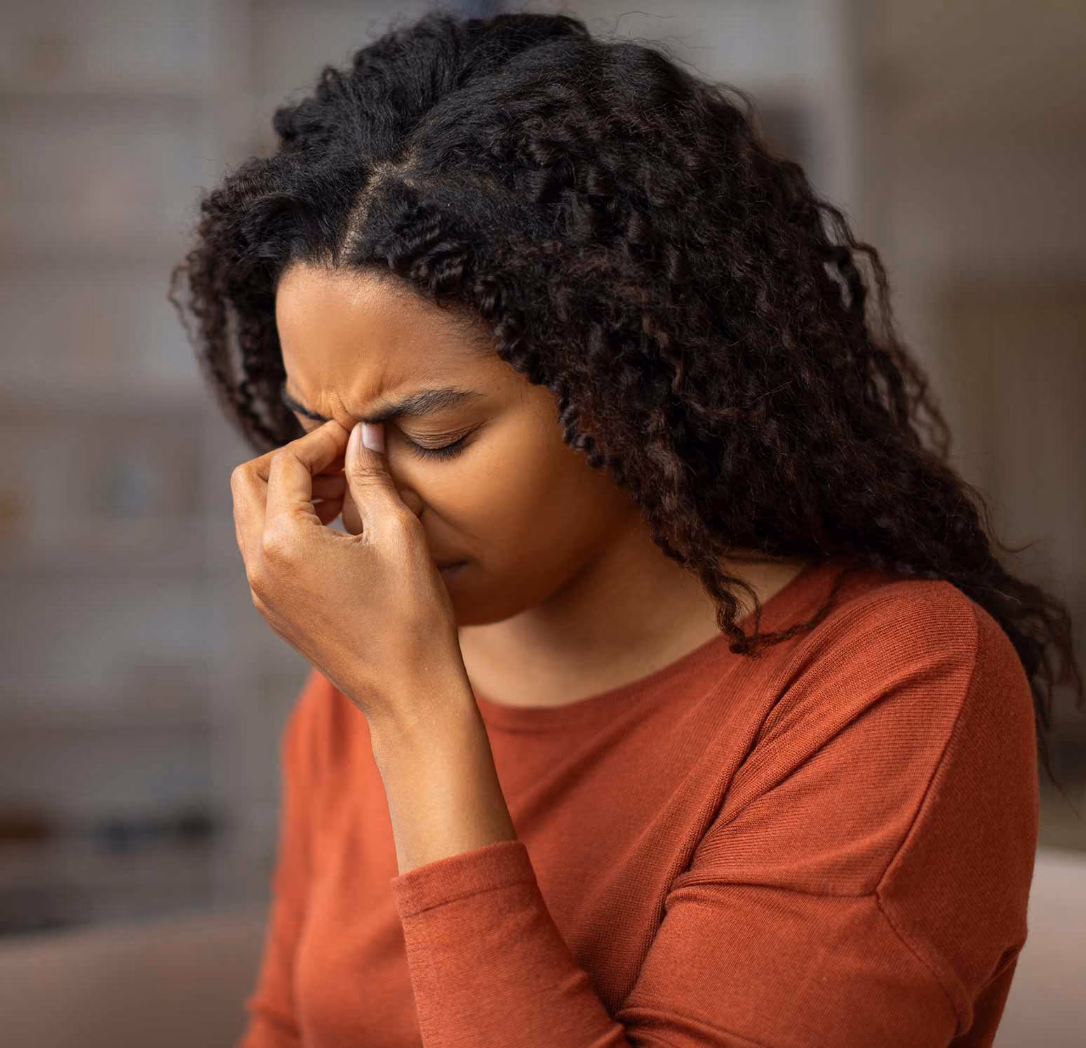 Young woman holding her sinuses in discomfort from sinus pain