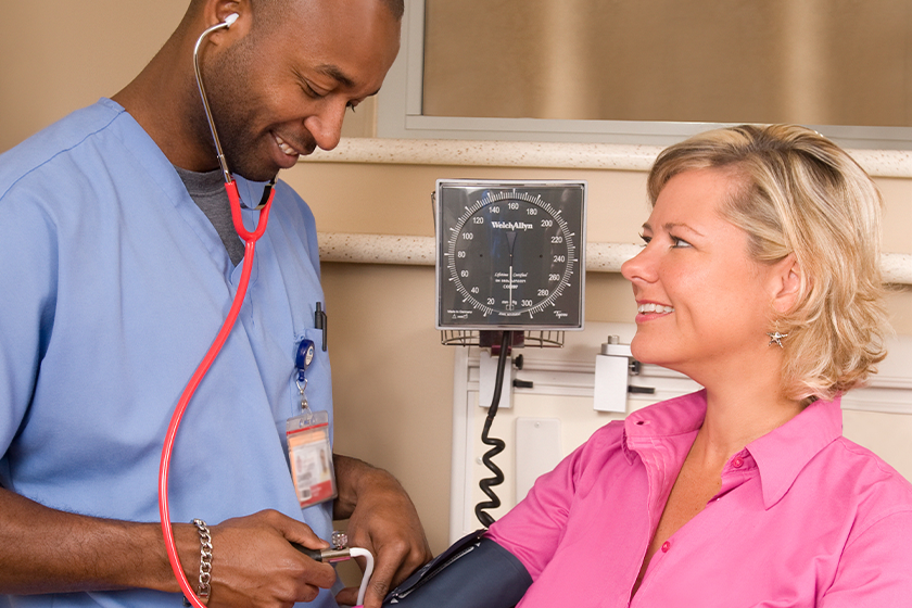 Nurse on the CareRev platform taking a patient's blood pressure