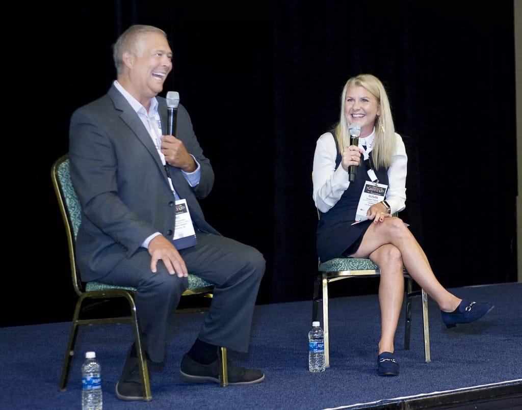 Susan Pasley and Eric Humphrey sit with microphones on stage at HFMA 2023.