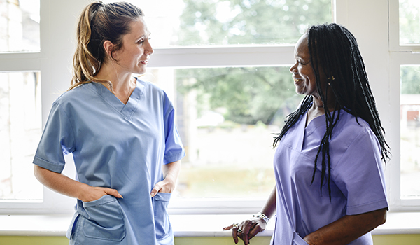 two CareRev nurses talking and smiling