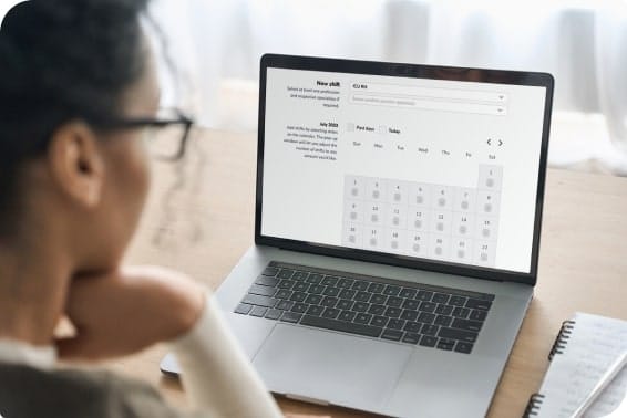 A healthcare employee looks at the CareRev workforce management platform on her laptop.