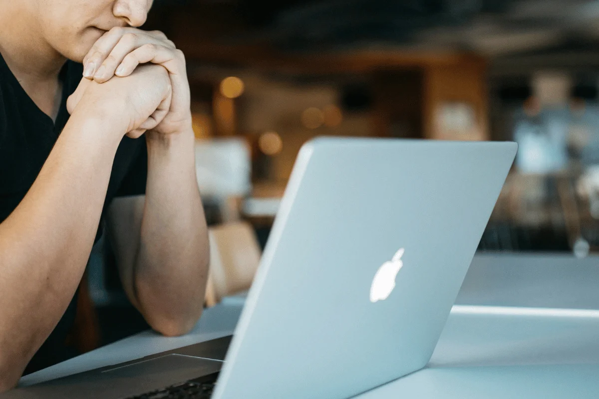 Person deep in thought while working on a laptop.