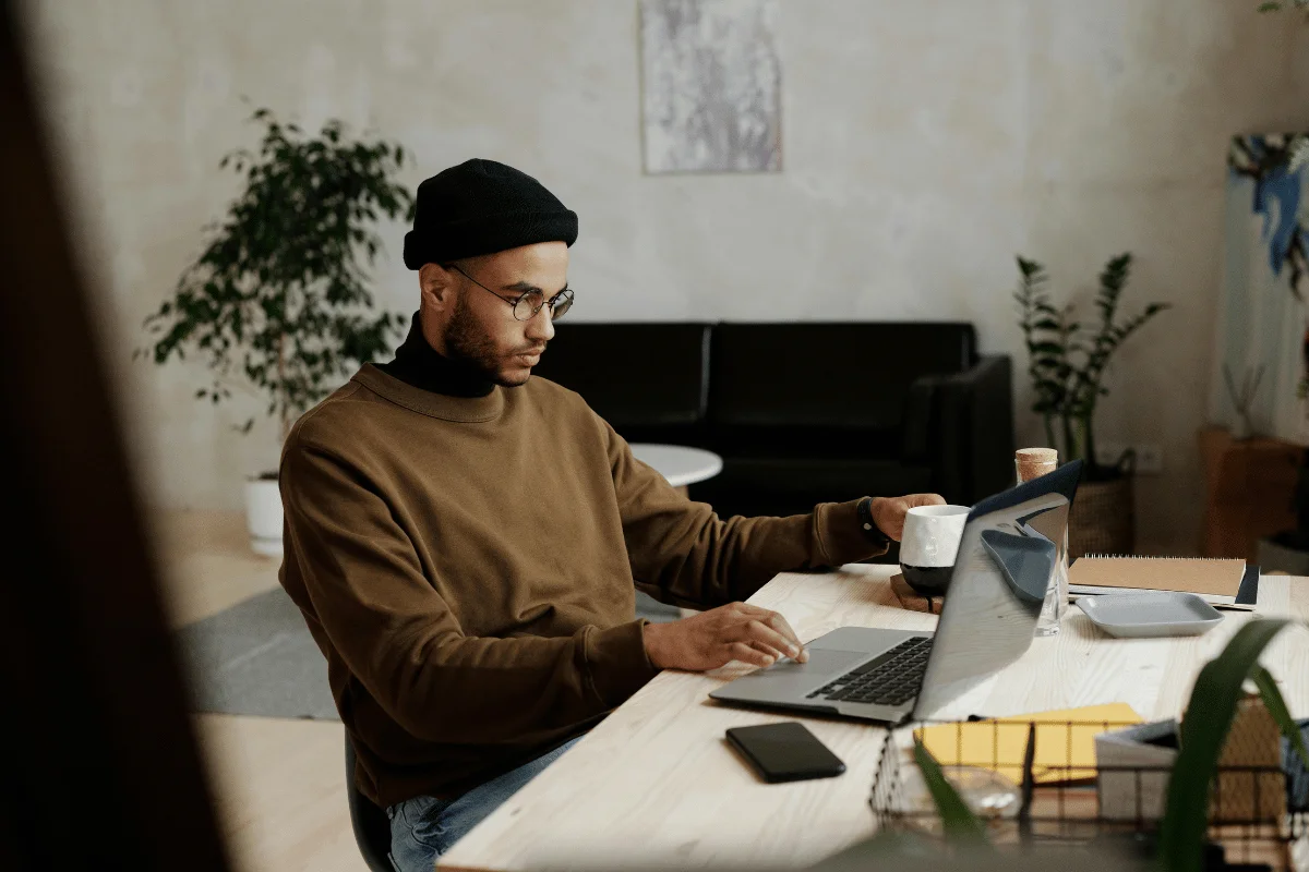 Man working on a laptop in a cozy workspace.