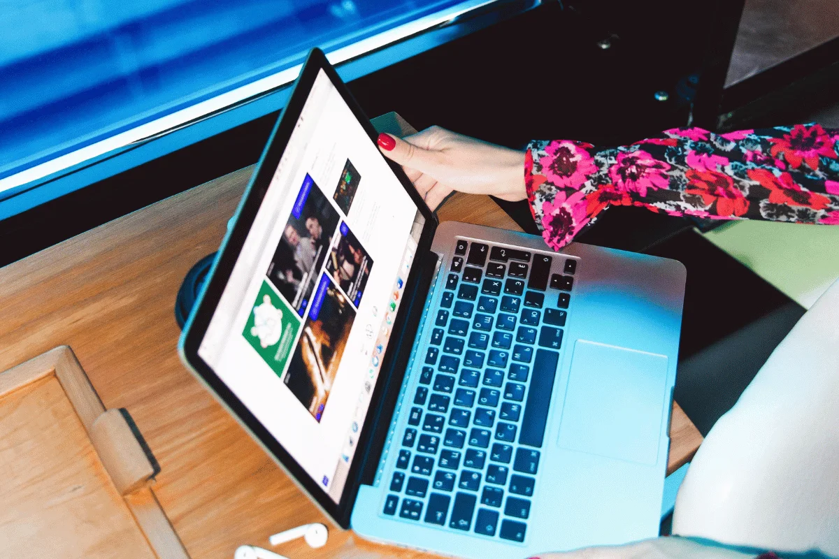 Person browsing on a laptop with a colorful floral sleeve.