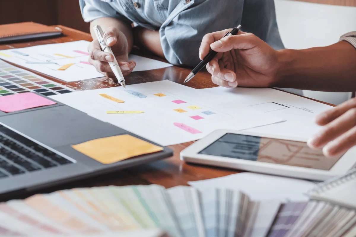 Designers reviewing color swatches and design plans at a workspace.