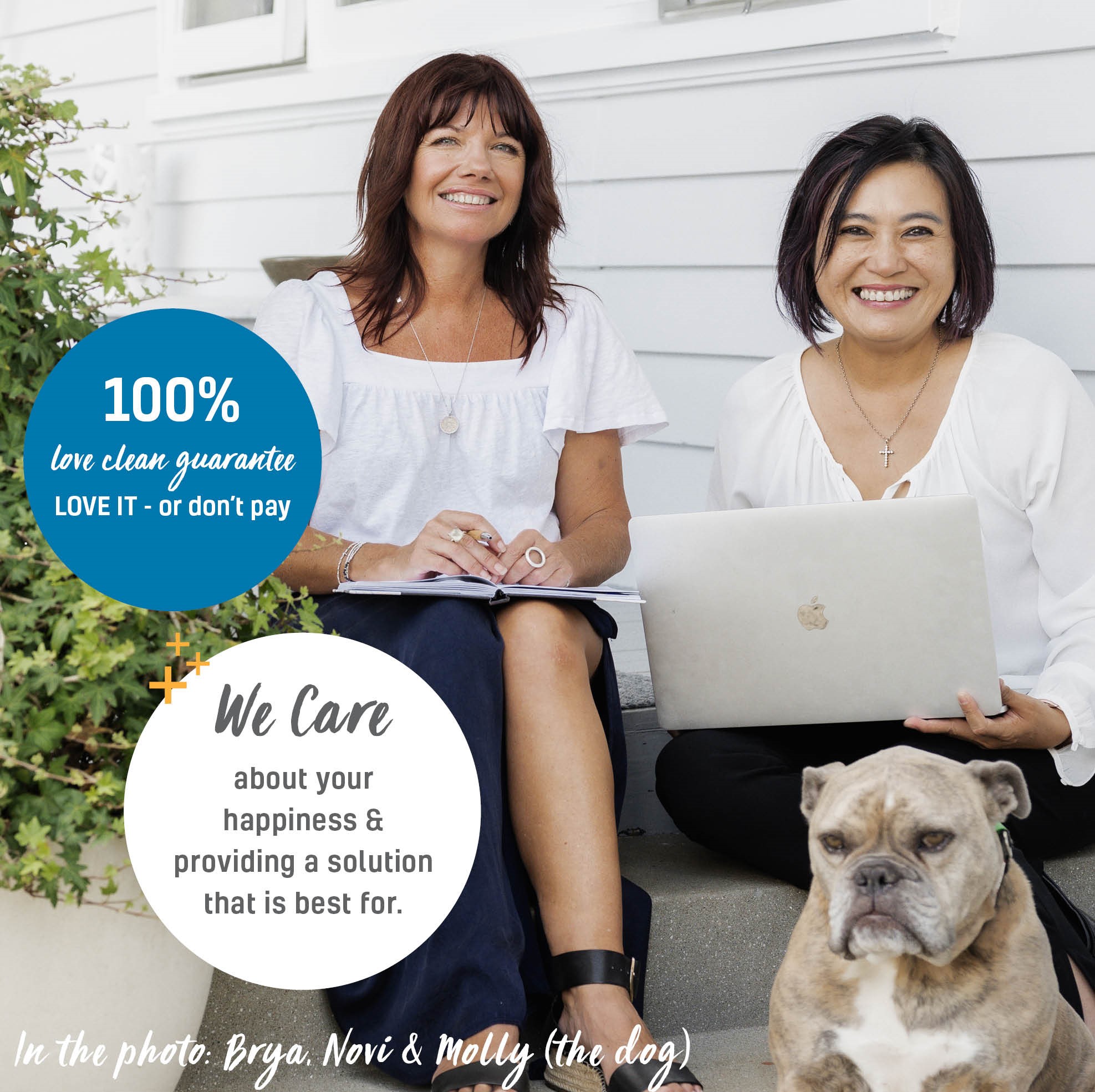 Two smiling women sitting on porch steps with a laptop and notebook, and a bulldog sitting in front of them.