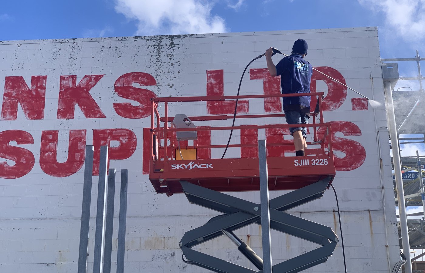 Blast Away Guys technician commercial building washing to remove lichen and mould buildup in Northland.