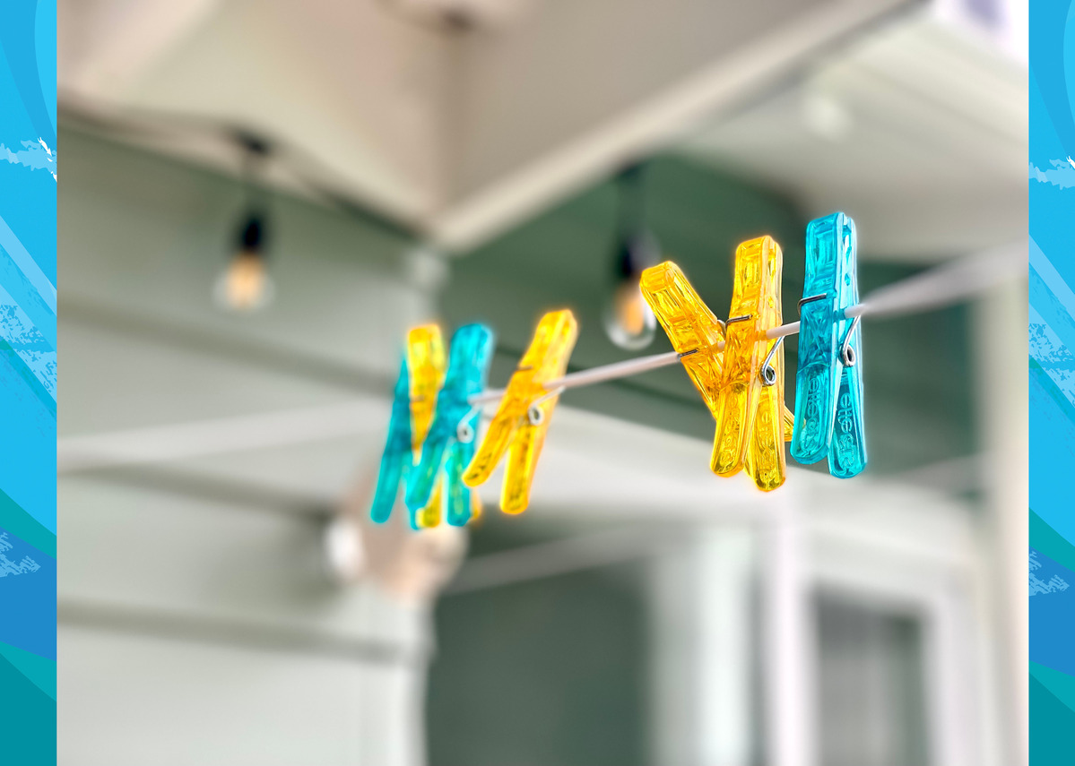 Yellow and blue pegs on an empty clothesline, ready for an exterior clean