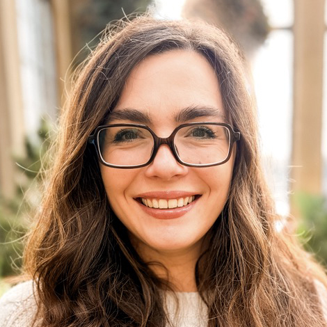 Woman with glasses and brown hair smiling