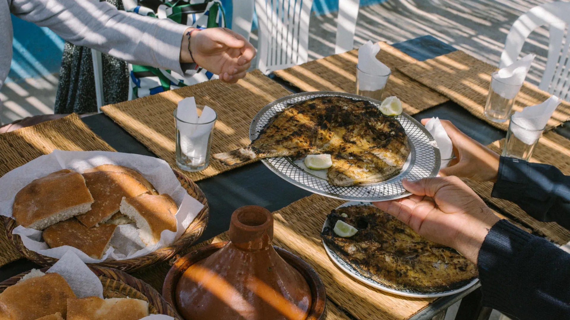 Fish lunch outside, people passing around a plate full
