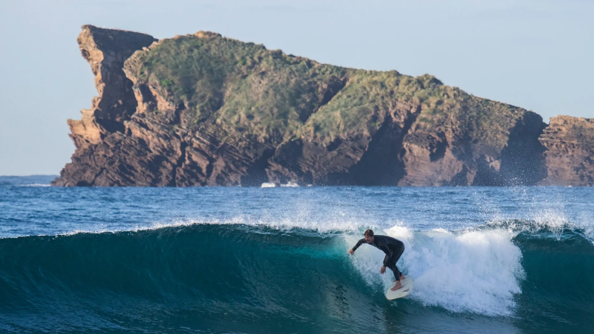 surfer dropping on a clean righthand wave
