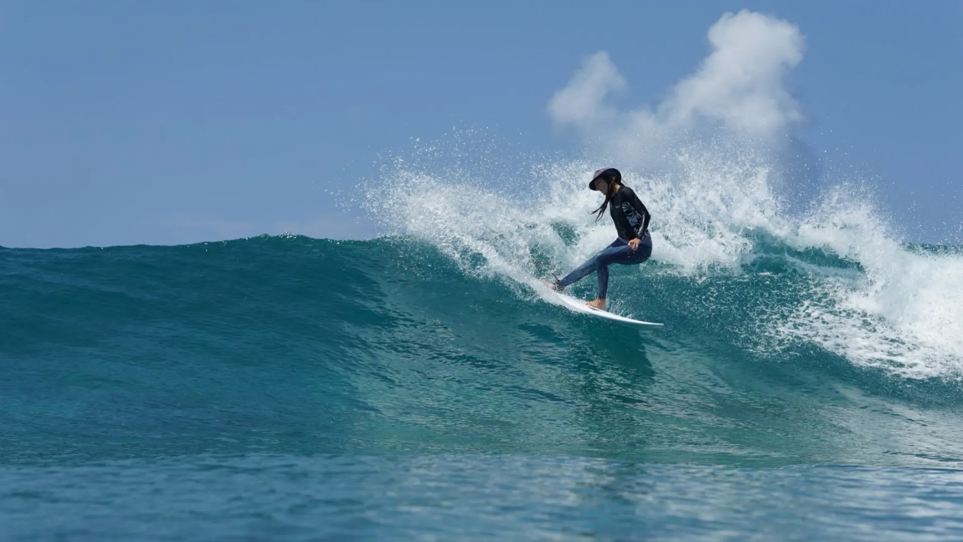 Girl surfer ripping a righthand perfect wave