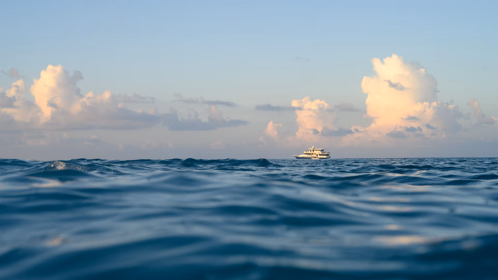 the boat in the middle of the blue ocean