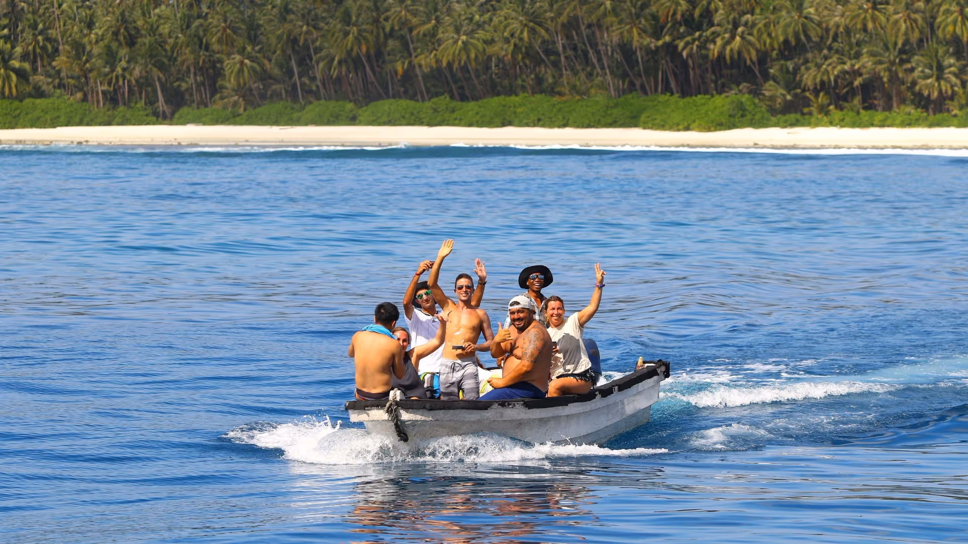 group of friends on a small boat in the mentawai