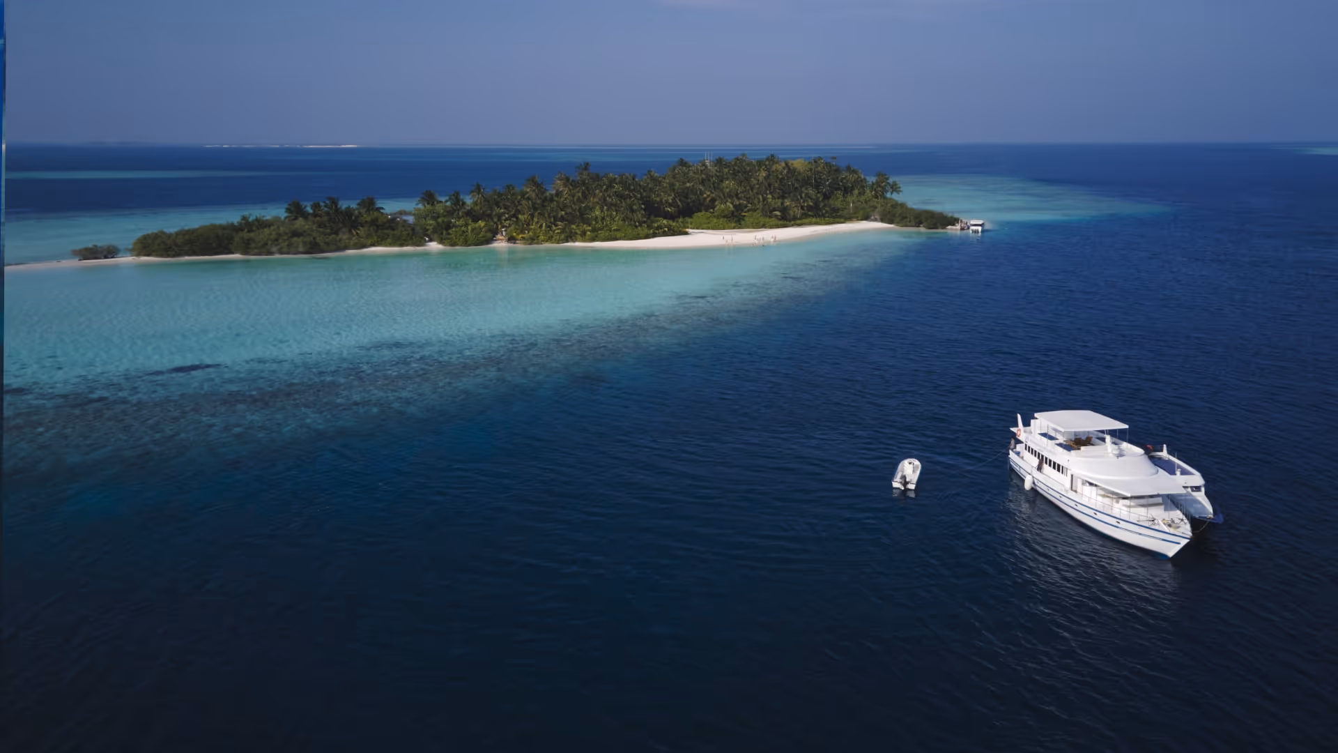 boat anchored next to a picturesque island in the Maldives