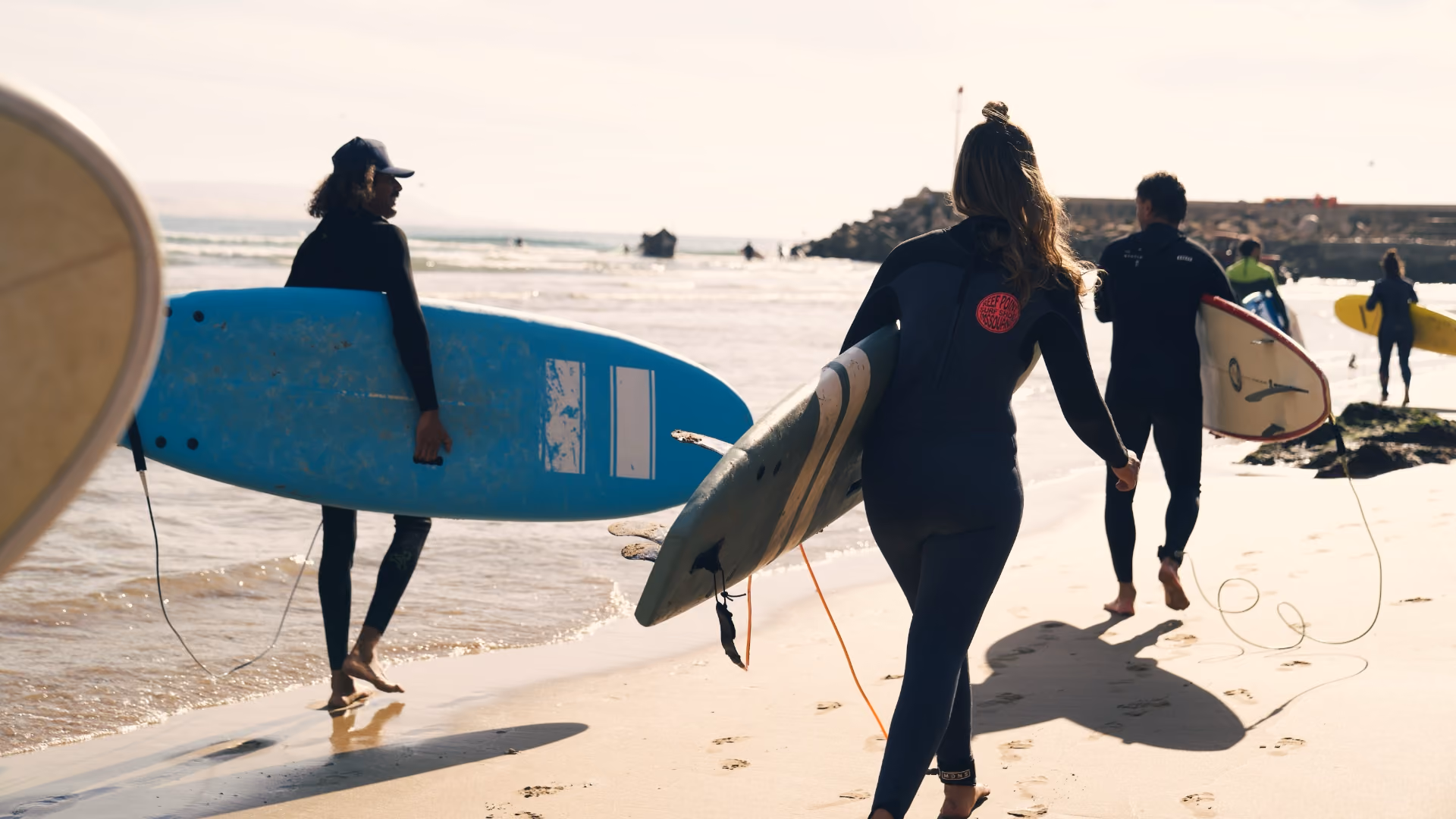 Anfänger mit Softtops auf dem Weg zum Meer in Imsouane, Marokko