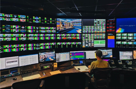 A person sitting at a desk with multiple screensAI-generated content may be incorrect.