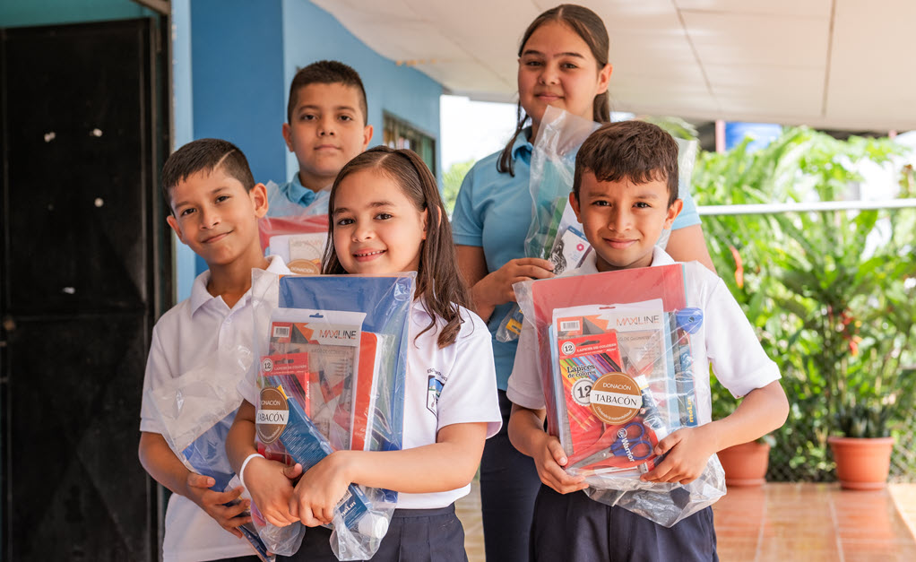 Students holding school supplies provided through Tabacón’s Checkout Donation Program.