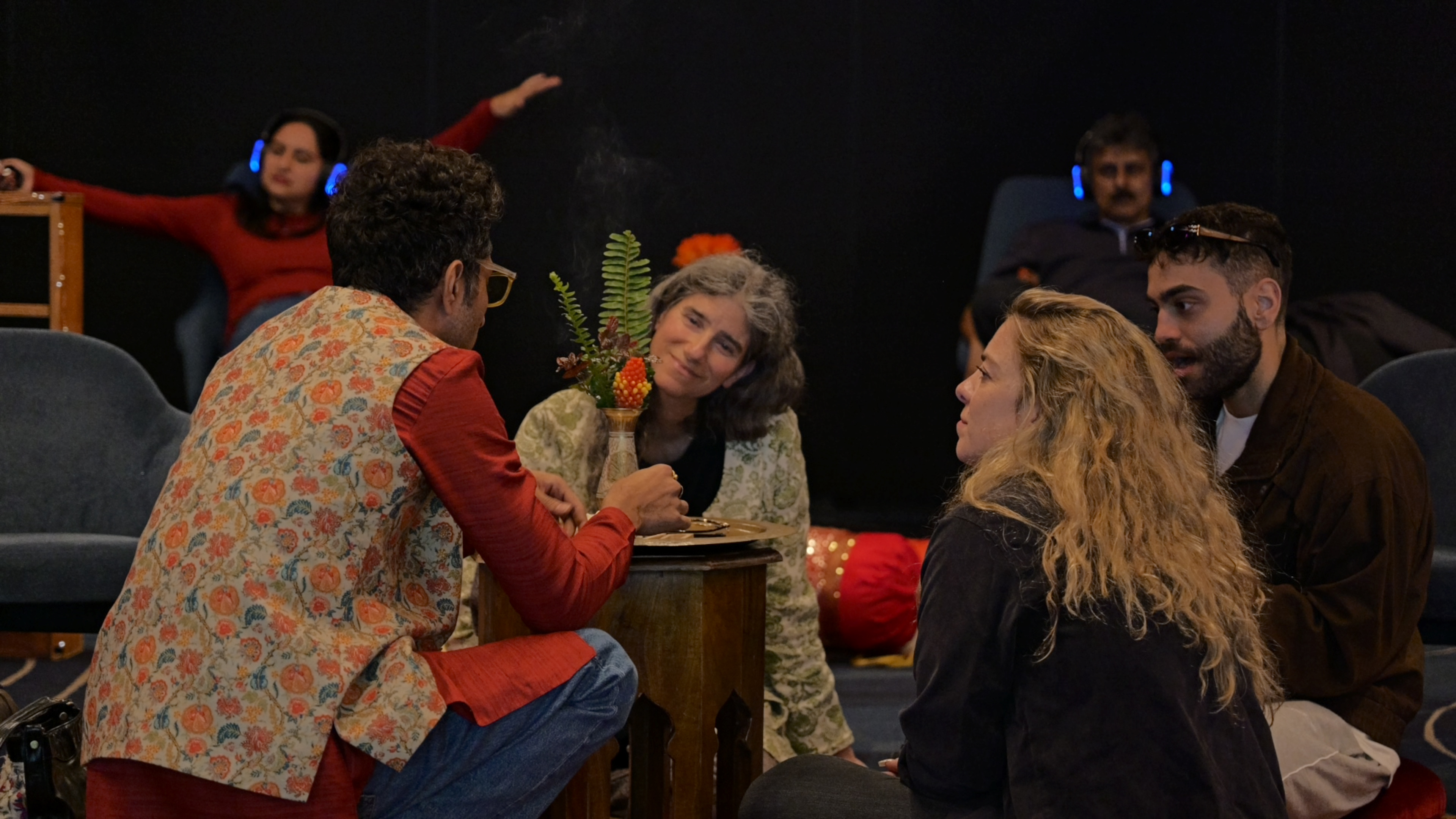 Guests sharing conversation beside a smoking incense burner