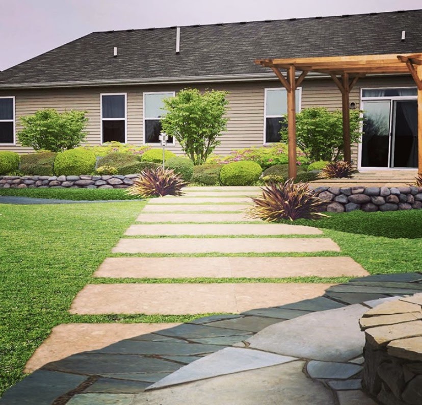 Backyard landscape design with stone walkway, pergola, lush green lawn, and manicured shrubs, showcasing a modern outdoor renovation transformation.