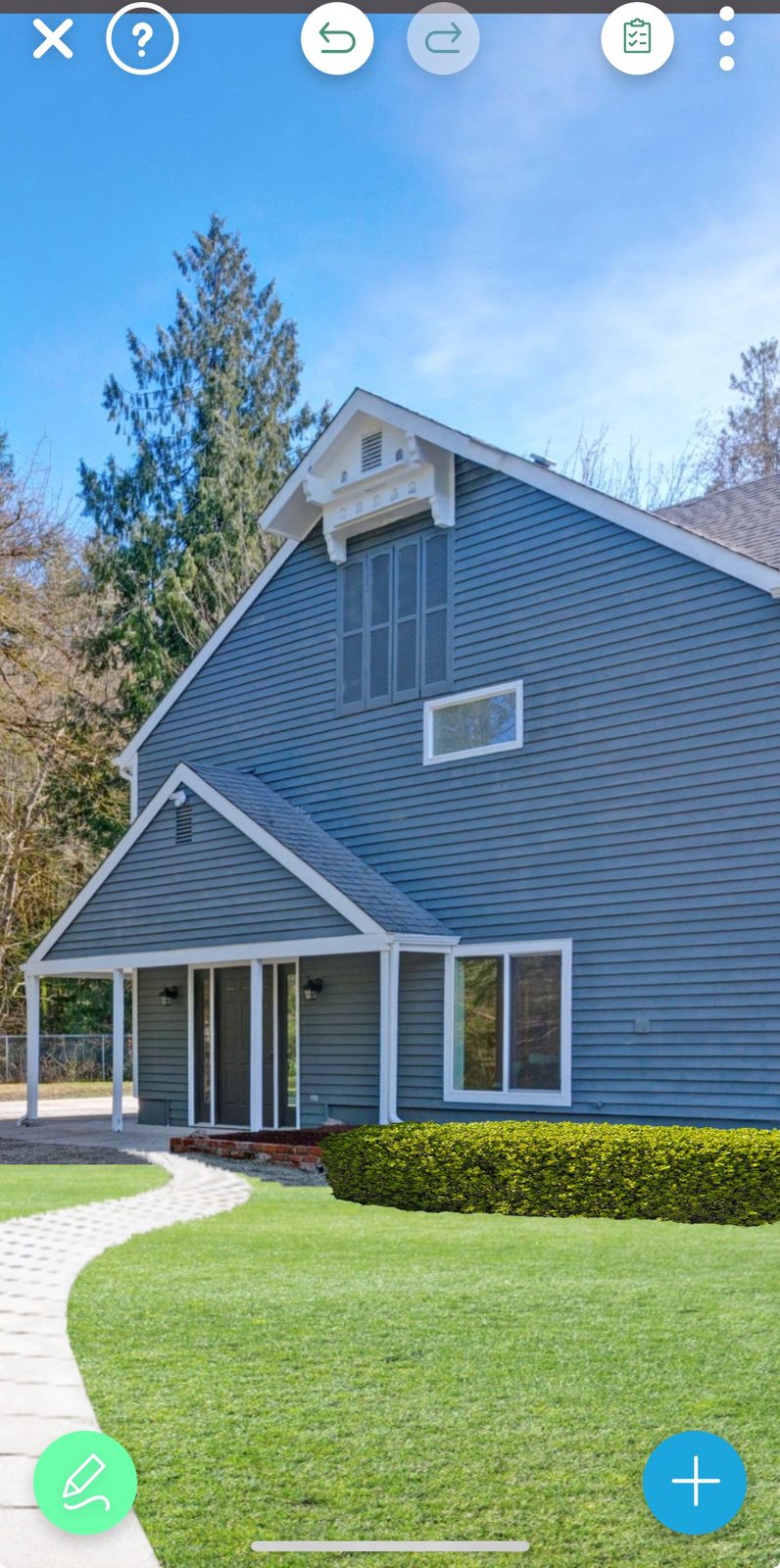 Front view of a modern gray home with white trim, a curved stone walkway, and neatly trimmed green hedge designed in the iScape app.