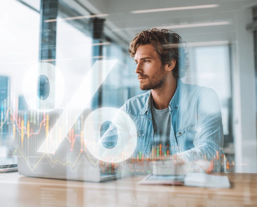 A man behind computer with graph overlay