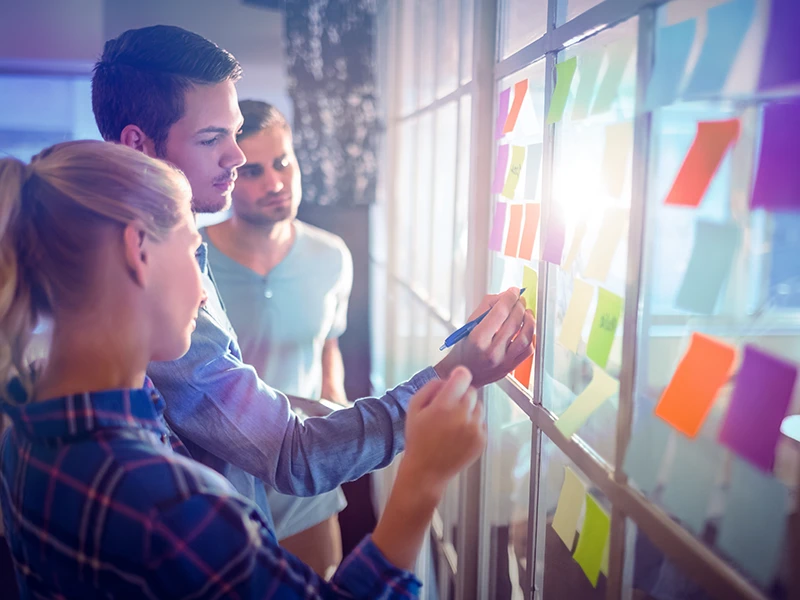Illustratives Bild von Menschen, die auf Post-its schreiben