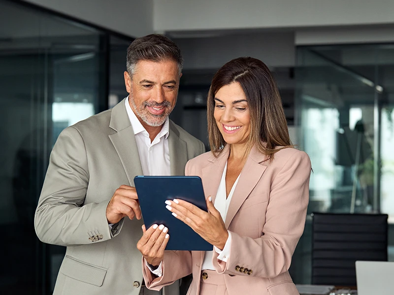 Illustratives Bild eines Mannes und einer Frau, die auf ein Tablet schauen