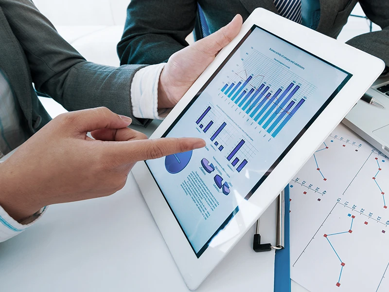 Illustratives Bild eines Mannes, der auf ein Tablet zeigt, auf dem Diagramme zu sehen sind