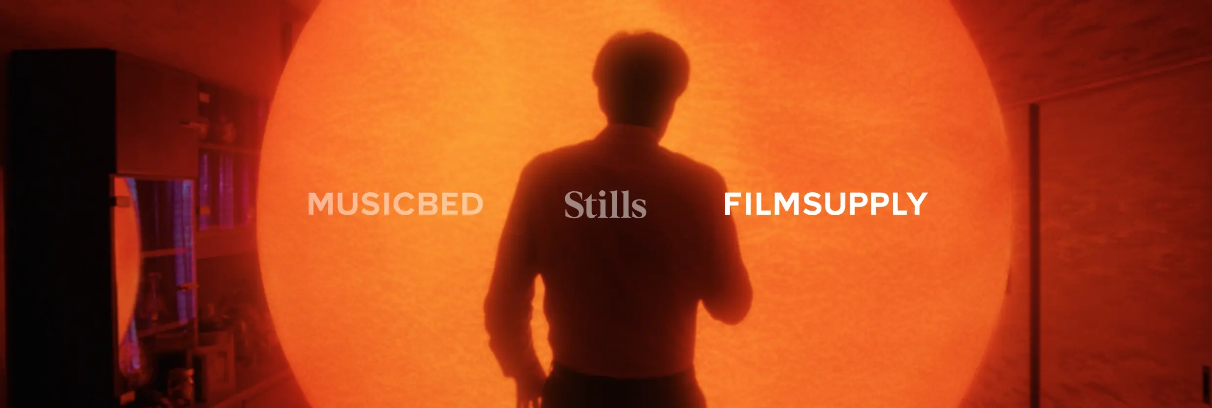 A person standing in front of a glowing sun-like sphere with the text Filmsupply overlaid