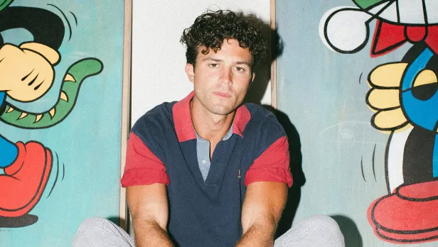 Motorcycle riding on a dirt road winding through a rocky desert canyon landscape.