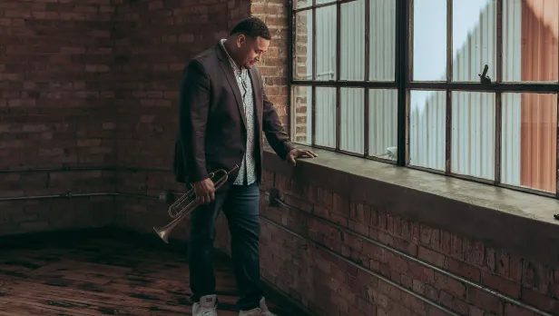 Motorcycle riding on a dirt road winding through a rocky desert canyon landscape.
