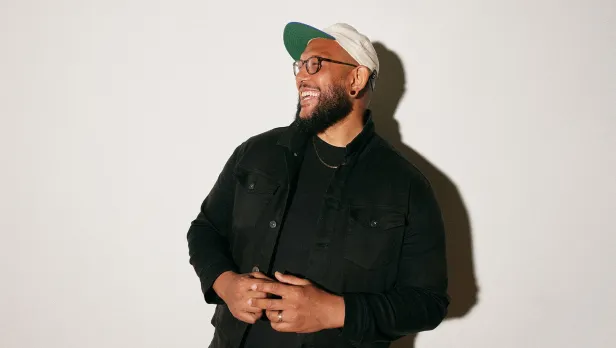 Motorcycle riding on a dirt road winding through a rocky desert canyon landscape.