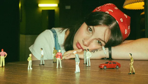 Motorcycle riding on a dirt road winding through a rocky desert canyon landscape.