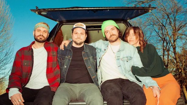 Motorcycle riding on a dirt road winding through a rocky desert canyon landscape.