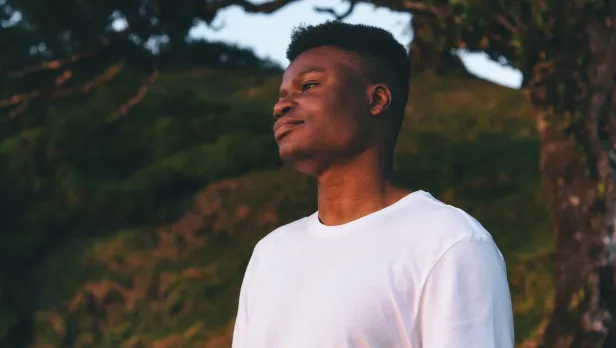 Motorcycle riding on a dirt road winding through a rocky desert canyon landscape.