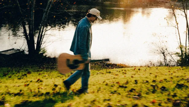Motorcycle riding on a dirt road winding through a rocky desert canyon landscape.